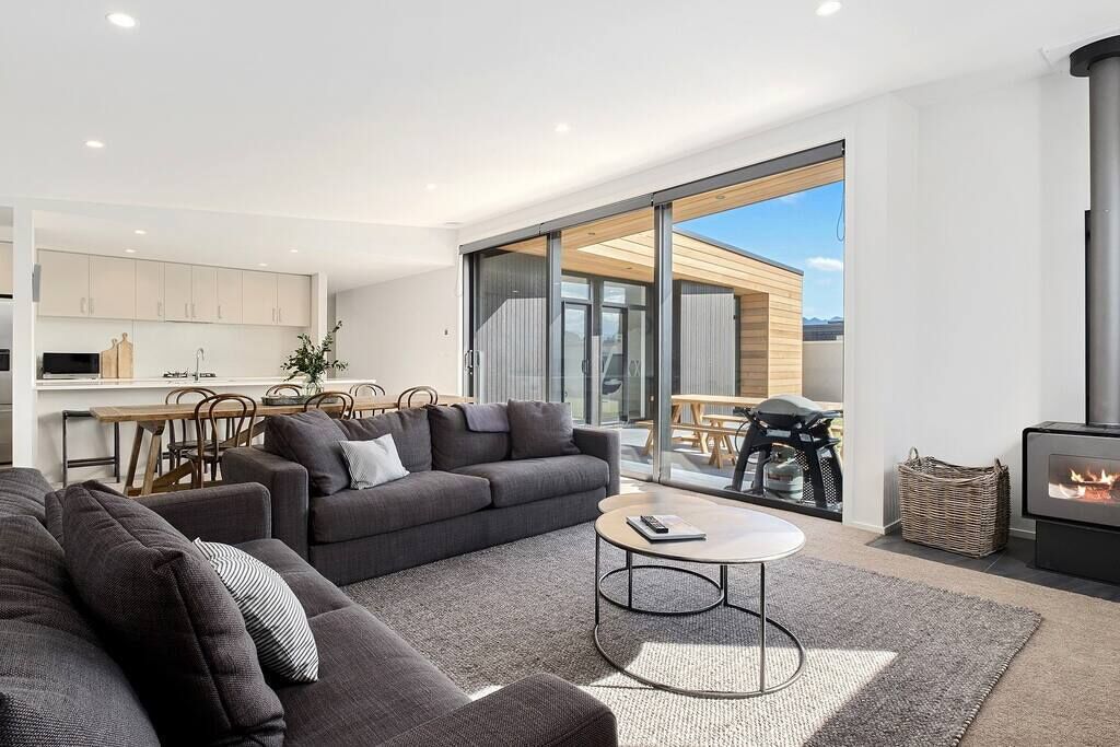 A modern living room with a sofa, coffee table, and a fireplace.