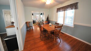 A dining area with a wooden table and chairs, a ceiling fan, and a window with blinds. - Walking distance to shopping, restaurants, entertainment, and the Chesapeake Bay (Rock Hall)