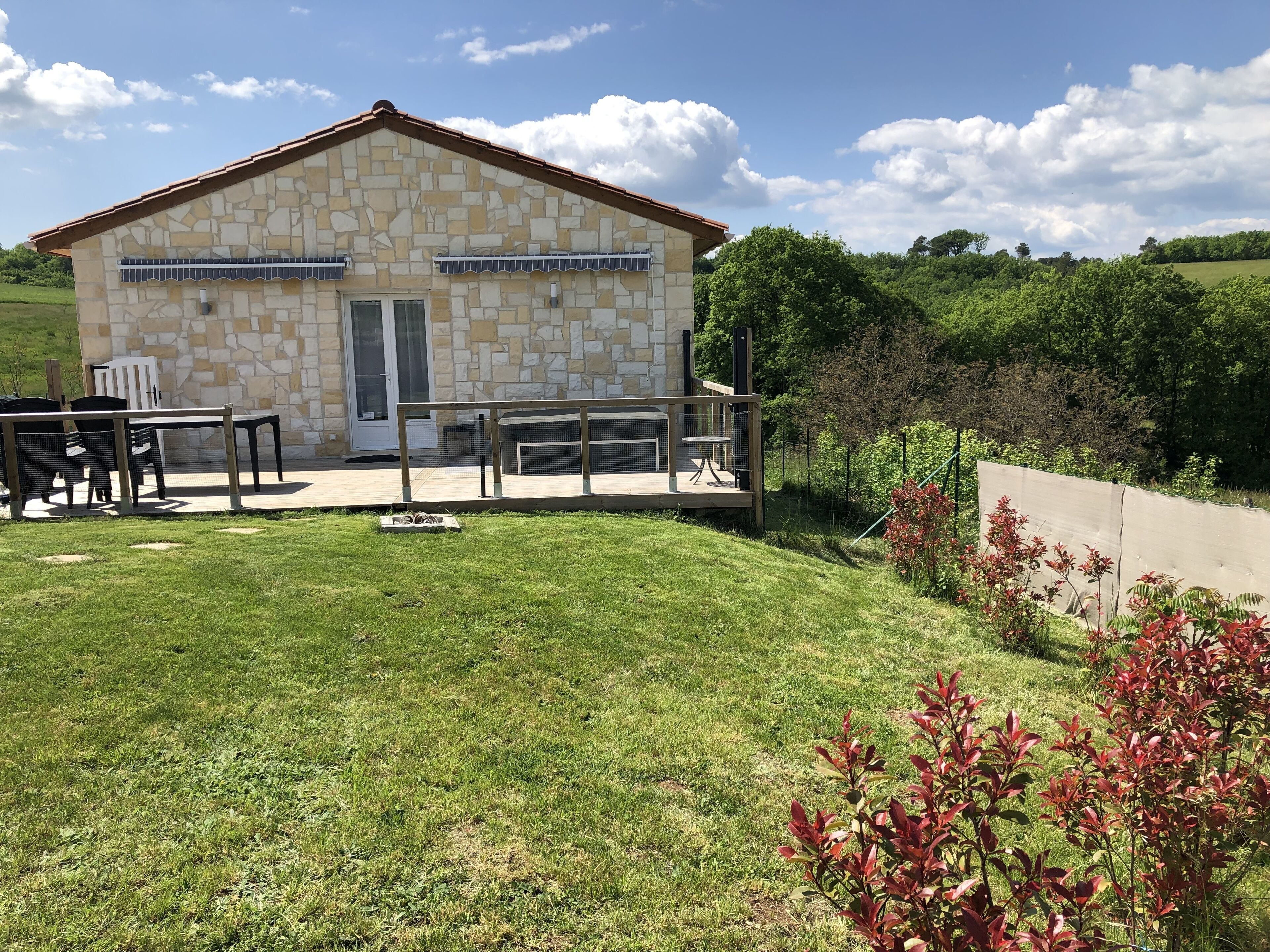 Un bâtiment en pierre doté d’un patio, d’un espace extérieur aménagé pour s’asseoir et offrant une vue sur un paysage verdoyant.