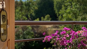Un balcon offrant une vue sur un paysage montagneux et une végétation luxuriante.