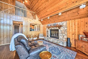 Cozy living area with a leather sofa, stone fireplace, and comfortable seating options.