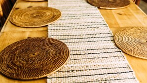 Une table à manger avec des sets de table en fibres tressées et des chaises.