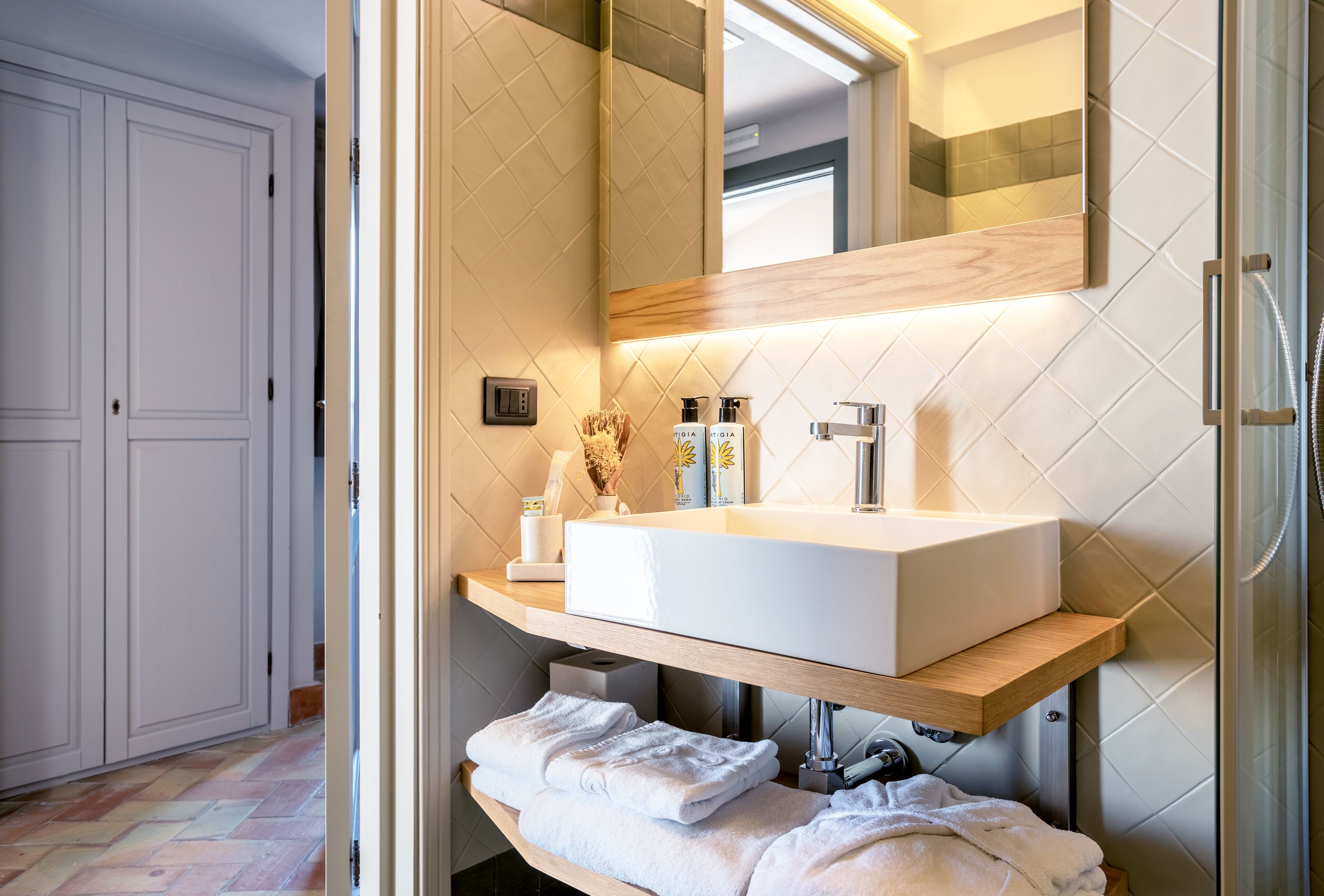 Une salle de bain moderne avec un grand lavabo blanc, un miroir et une douche.