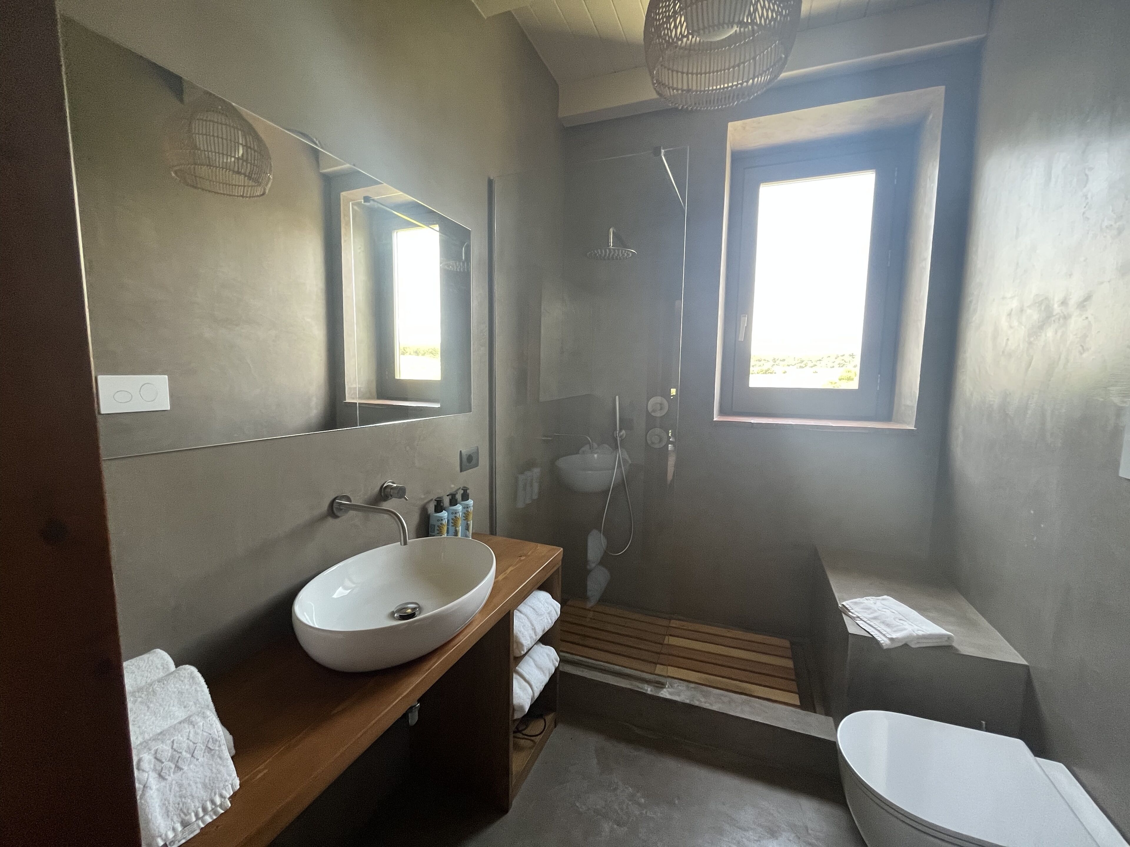 Une salle de bain moderne avec un grand miroir, un lavabo blanc, une douche et une baignoire.