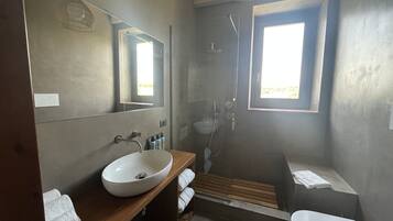 Une salle de bain moderne avec un grand miroir, un lavabo blanc, une douche et une baignoire.