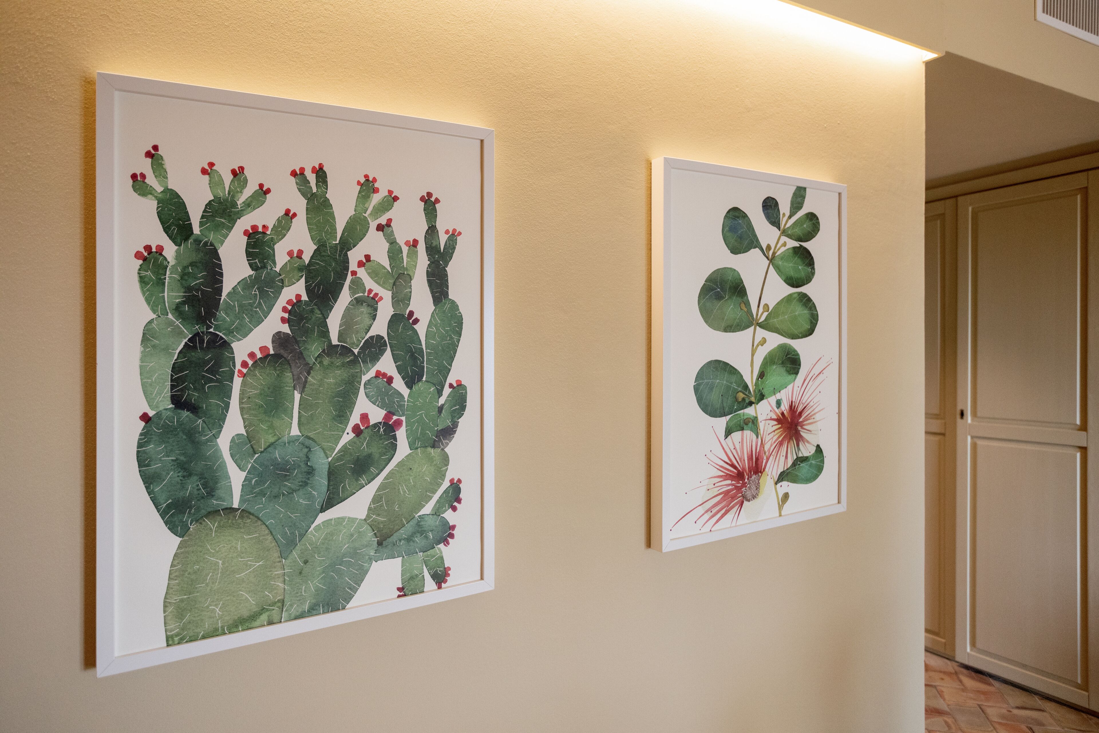 Zwei gerahmte Pflanzenillustrationen an einer Wand.