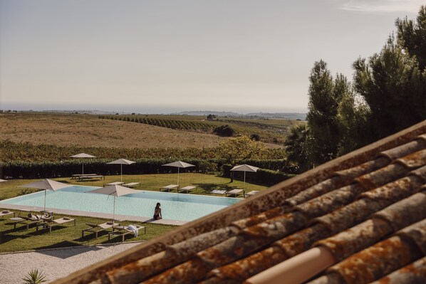 Piscine extérieure, parasols de plage, chaises longues