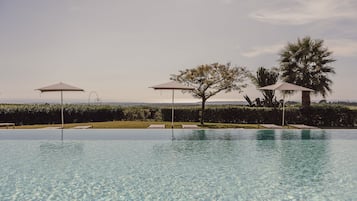 Piscine extérieure, parasols de plage, chaises longues