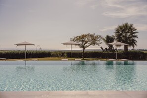 Piscine extérieure, parasols de plage, chaises longues