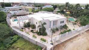 A residential property with a swimming pool, a covered patio, and a fenced yard.