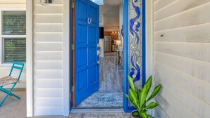 A bright blue door leading into a house with a kitchen visible through the doorway. - River's Edge Retreat (St. Augustine)