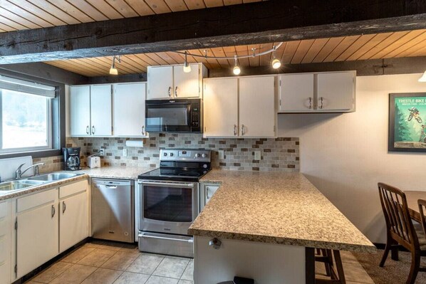 Enjoy cooking in this well-equipped kitchen with a stainless steel oven, microwave, and granite countertop.
