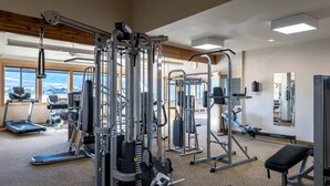 A gym with various exercise equipment, large windows, and a view of the mountains. - Fraser 3BR Condo with Pool and Hot Tub (Fraser)