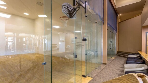 A modern office space with a glass partition, a basketball hoop, and a wooden bench. - Fraser 3BR Condo with Pool and Hot Tub (Fraser)