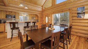 A log cabin interior with a dining area, kitchen, and large windows. - Rocky Mountain cabin w/ fireplace & deck (Grand Lake)