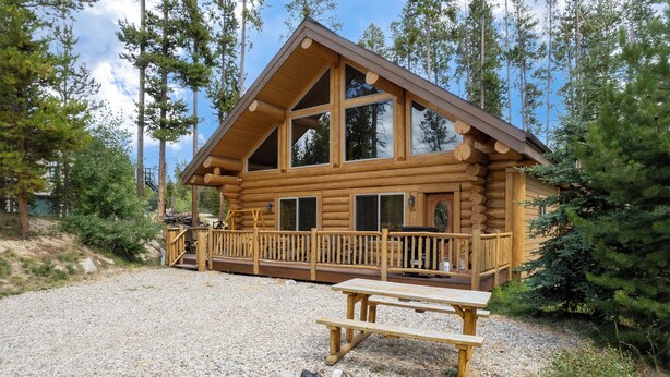 A log cabin with a wooden deck, a fire pit, and a view of the surrounding forest. - Rocky Mountain cabin w/ fireplace & deck (Grand Lake)