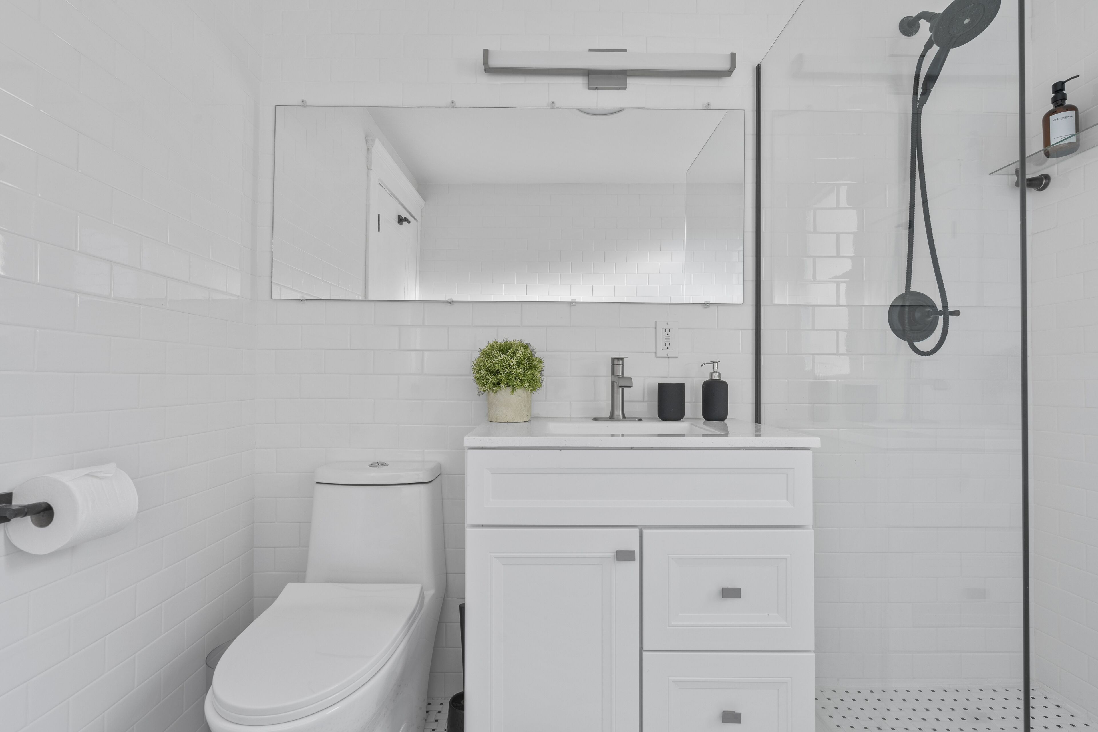 Un baño moderno con inodoro, lavamanos y ducha.
