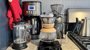A kitchen with a coffee maker, a scale, and a coffee grinder. - Modern 4 Bedroom Beach House: Ideal for Families & Long Stays (West Haven)
