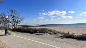 A coastal walkway with benches, a lamp post, and a clear view of the sea. - Modern 4 Bedroom Beach House: Ideal for Families & Long Stays (West Haven)