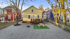 Une petite maison de plain-pied avec une terrasse à l’avant et une table de pique-nique.