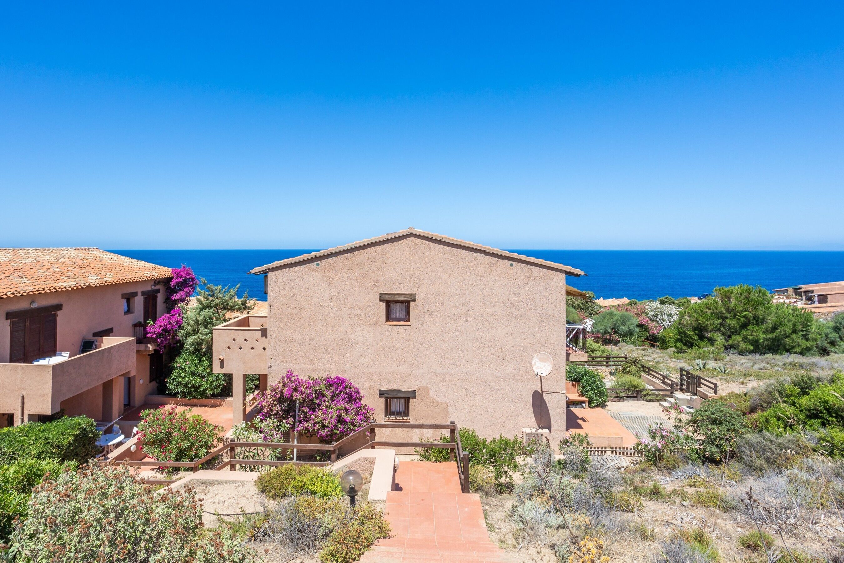 Ein Gebäude mit Flachdach, Satellitenschüssel und Blick aufs Meer.