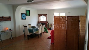 A dining area with a table, chairs, and a decorative wall piece.