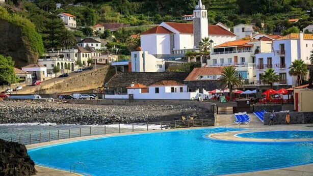 Une station balnéaire dotée d’une grande piscine, de villas en bord de mer et d’une église.