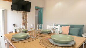 A dining table set with plates, glasses, and a television mounted on a stone pillar. - Farmhouse 'Al Posto Giusto - Gioia' with Shared Garden, Wi-Fi and Air Conditioning (Riotorto)