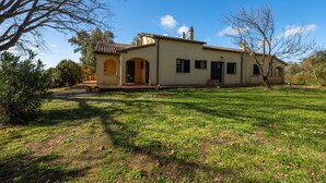 A single-story house with a tiled roof, an arched doorway, and a small porch. - Agriturismo "Rosaspina - Apartment 3" with Shared Pool and Garden (Capalbio)