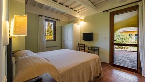 A bedroom with a bed, a TV, a desk, and a window. - Agriturismo "Rosaspina - Apartment 3" with Shared Pool and Garden (Capalbio)