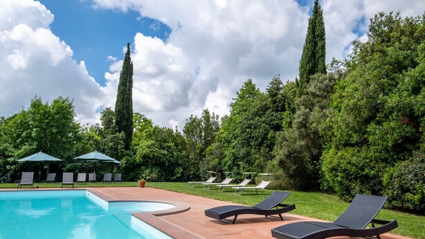 A swimming pool with lounge chairs and umbrellas, surrounded by greenery and trees. - Agriturismo "Rosaspina - Apartment 3" with Shared Pool and Garden (Capalbio)