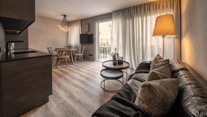 Ein modernes Wohnzimmer mit einer Couch, einem Esstisch und einer Küchenzeile.