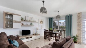 A modern living room with a sofa, TV, dining table, and decorative items. - Holiday Home "Duplex India" with Wi-Fi (Tacoronte)