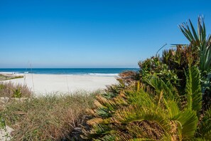 A beach with white sand, clear blue sky, and ocean. - Ocean Breezes (St. Augustine)