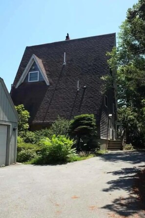 A house with a steeply pitched roof, a small window, and a garage. - Sunny and Spacious A-Frame nestled in the fir trees. Mountain views! (Tremont)