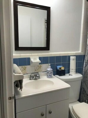 Een bad/douchecombinatie, een haardroger, handdoeken, zeep