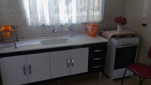 Una cocina con un fregadero, estufa y armarios.