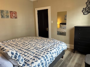 A bedroom with a bed, dresser, and artwork on the walls. - Hudson #1, Private Two Bed near Xavier & Downtown (Cincinnati)