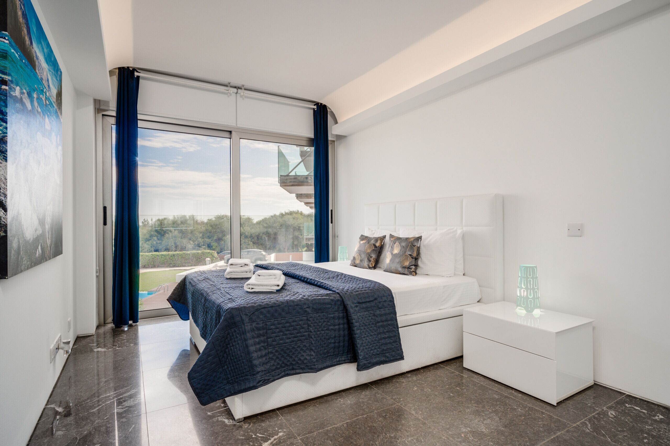 Una camera da letto moderna con un letto grande, un comodino e vista sull'esterno.