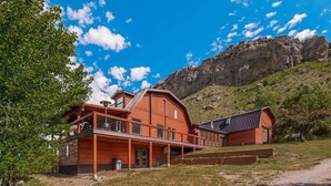 Ein großes Holzhaus mit Balkon, Garage und Bergblick.