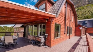 Eine Holzterrasse mit Gartenmöbeln und einem überdachten Bereich.