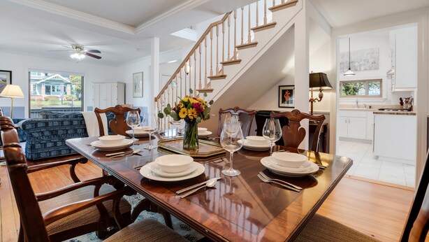A dining area with a wooden table set for six, a staircase, and a view of the backyard. - The Wayside: New in the Heart of Town (Dundee)