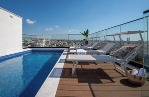 A rooftop pool with lounge chairs and a city view. - Sanders Crystal 1 - Large 4-bdr Penthouse With Shared Pool (Limassol)
