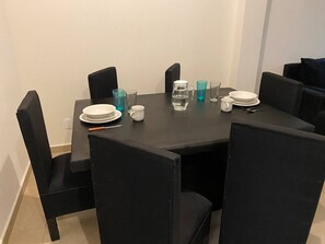 A dining table with four chairs, a pitcher, glasses, and plates. - Hermosa Casa Con Laguna Y Alberca (Veracruz)