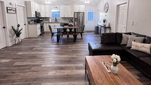 A spacious living area with a dining table, a sofa, and a ceiling fan. - Mountain View Modern Cottage in the Smokies W/ Hot Tub, Newly Renovated. (Sevierville)