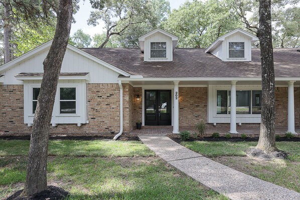 A two-story house with a brick facade, white trim, and a front porch.