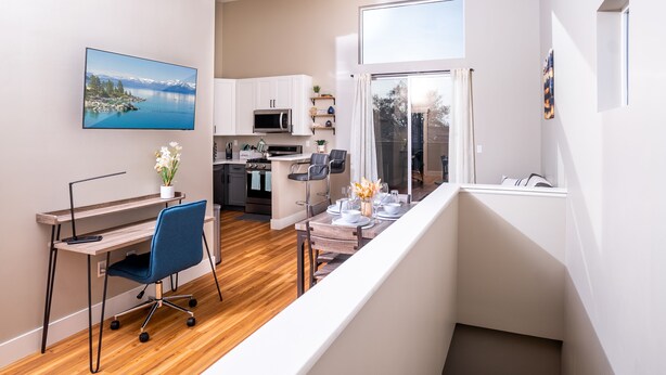Eine moderne Wohnung mit Essbereich, Küche und einem Balkon mit Ausblick.