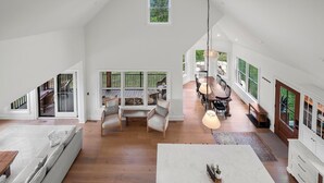 A spacious loft with high ceilings, large windows, a dining area, and a cozy seating area. - Cliffside Cottage, Private Pond, 50 acres w/ Breathtaking views near Galena, IL (Elizabeth)