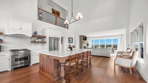 A spacious kitchen with a large island, a dining area with a high view, and a cozy seating area with a fireplace. - Cliffside Cottage, Private Pond, 50 acres w/ Breathtaking views near Galena, IL (Elizabeth)