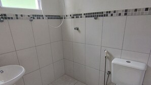Un baño con inodoro, lavamanos y ducha.